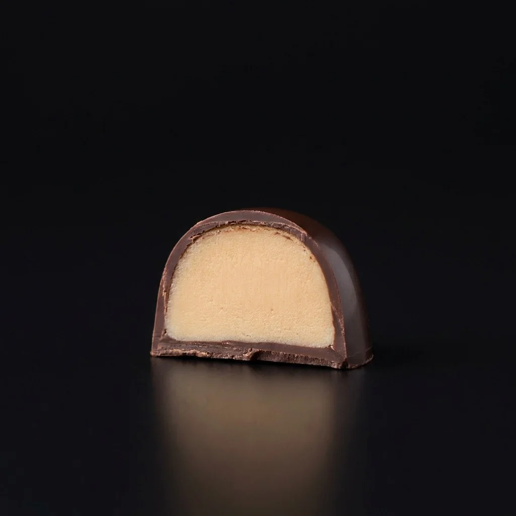 Bombón de Ganache de macadamia, cortado para mostrar el relleno