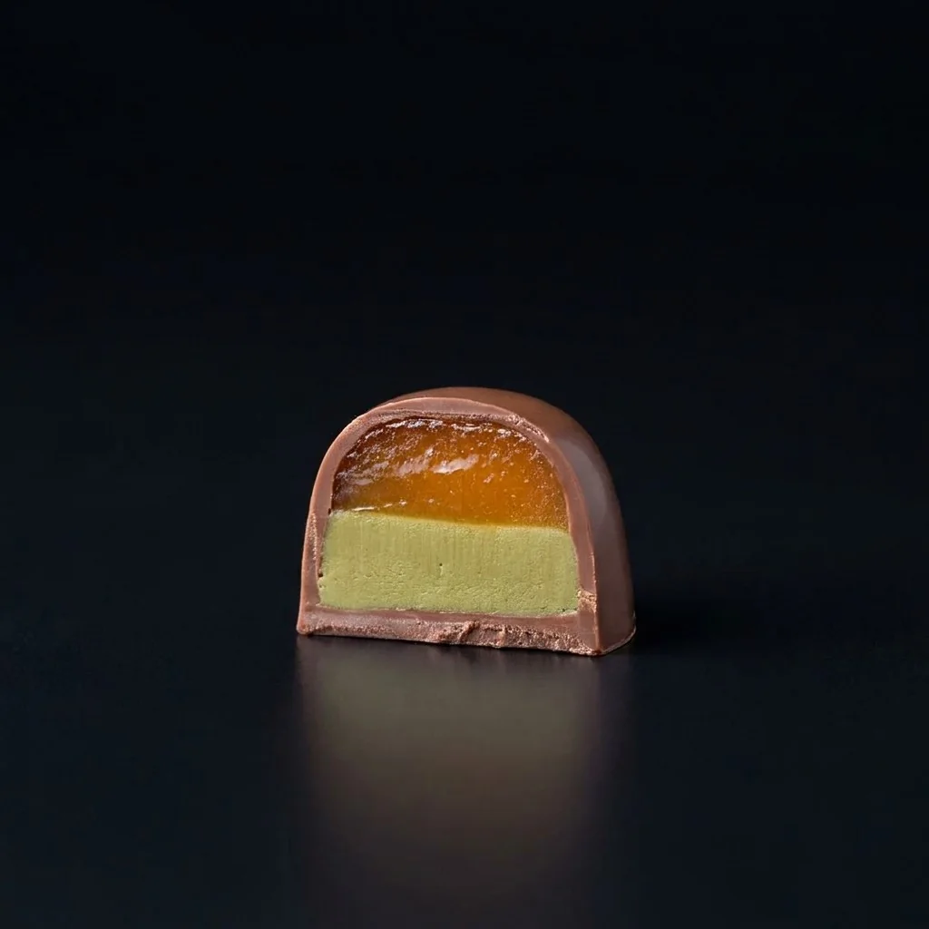 Bombón de Naranja y pistacho, cortado para mostrar el relleno