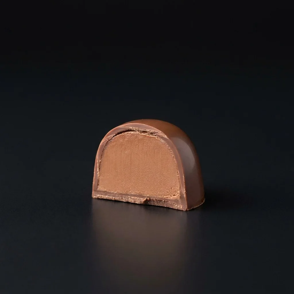 Bombón de Ganache de café y amaretto, cortado para mostrar el relleno
